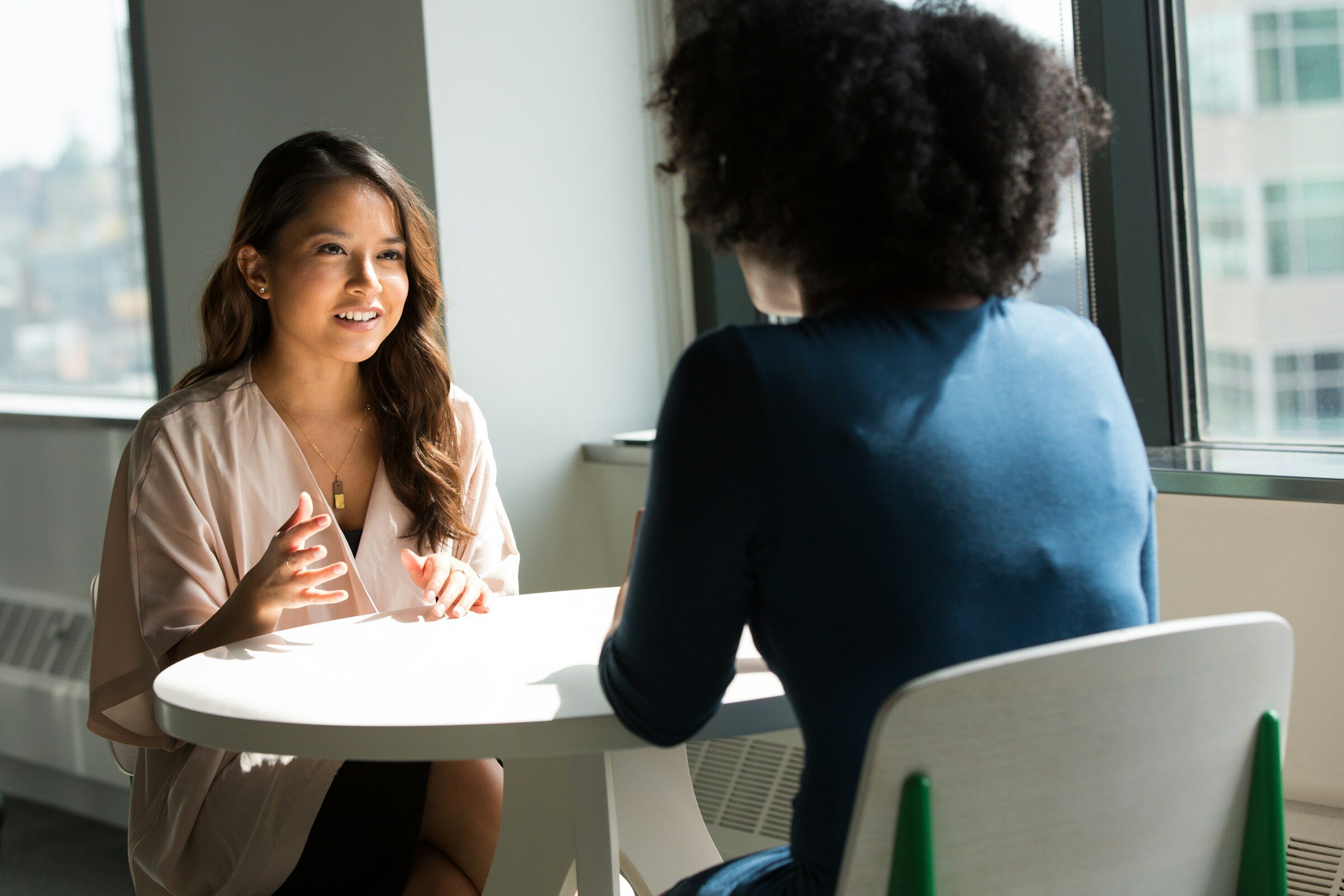 Two women in conversation at a small table